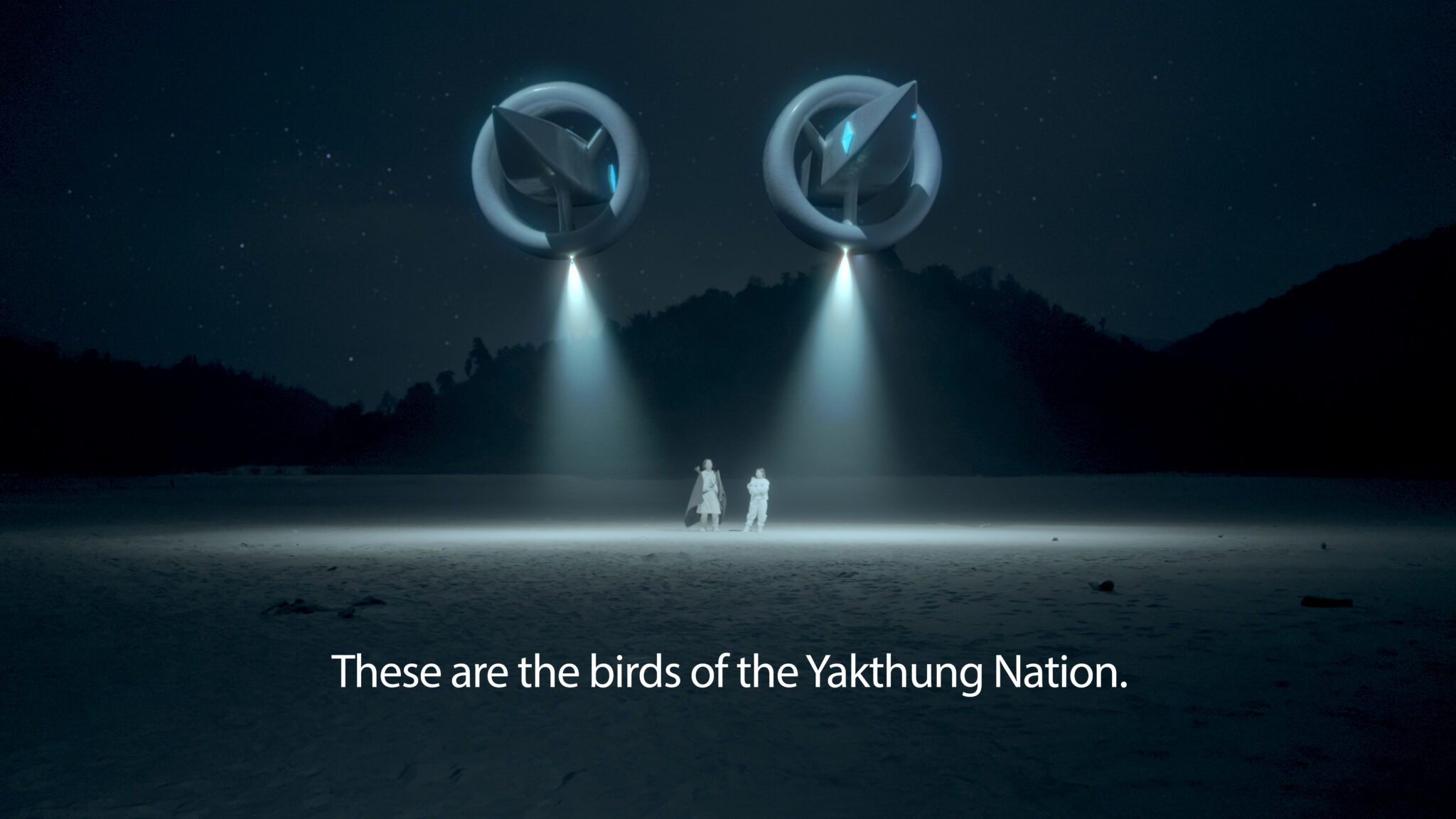 Still Image from Subash's Video. In the image are two floating, UFO-like structures casting light onto a dark landscape. In the background are dark, black mountains against a night sky with faint starlight. There are two small people standing beneath the UFOs. Subtitles read, "These are the birds of the Yakthung Nation."
