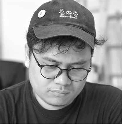 Black and White photo of artist and filmmaker, Riar Rizaldi. He wears glasses and a baseball cap and is looking down.